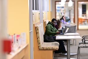 student studying on a bench with a table in APEX