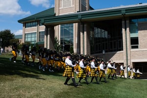 Band and football team marching down the hill