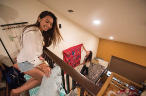 Students hanging poster in room