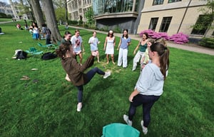 Students playing hacky stack on the lawn